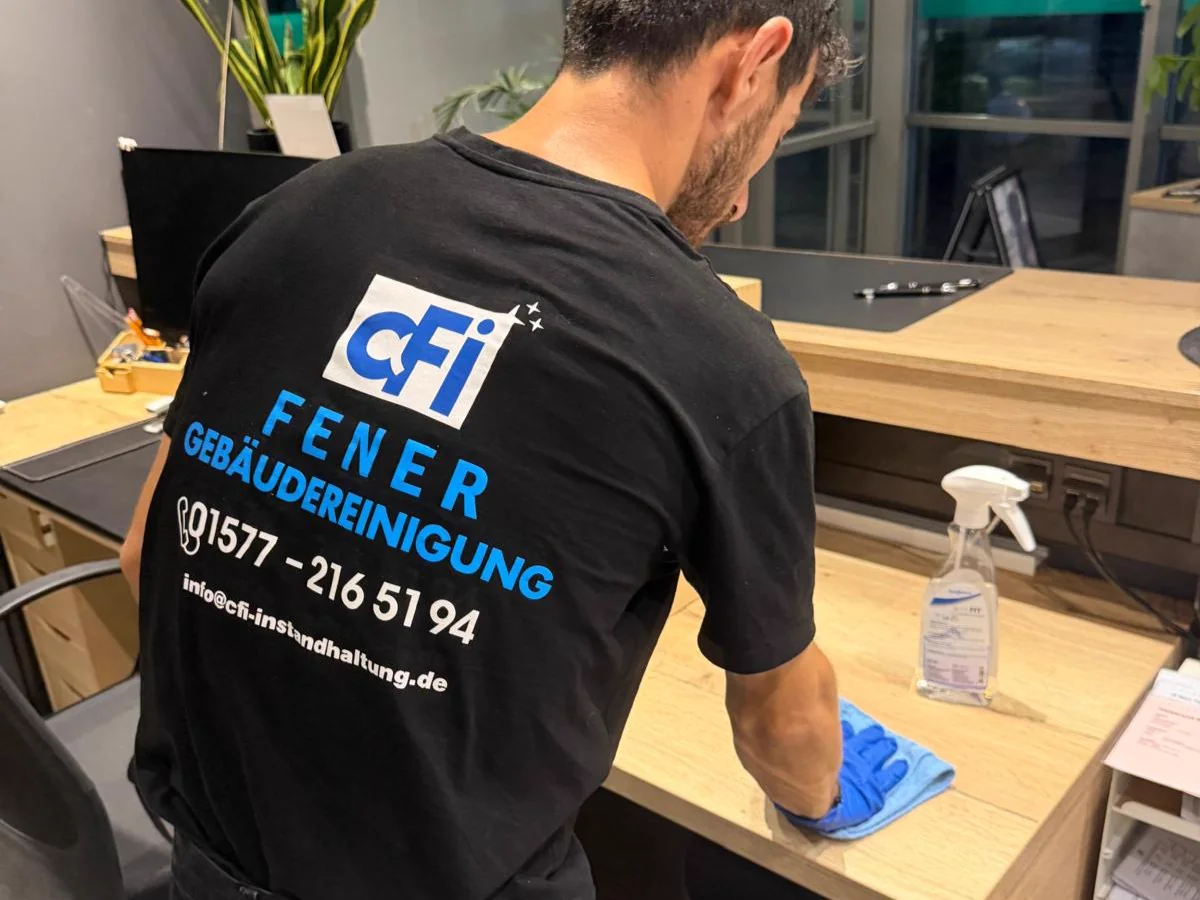 CFI-Mitarbeiter bei der Unterhaltsreinigung eines Arbeitsplatzes